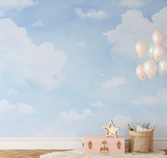 a baby's room with balloons and a suitcase on the floor in front of it