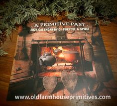 a book about primitive past sitting on top of a wooden table next to pot and pans