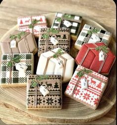 decorated christmas cookies on a plate with bows and presents tied to the top, sitting on a wooden table