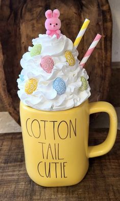 a yellow cup filled with white frosting and candy