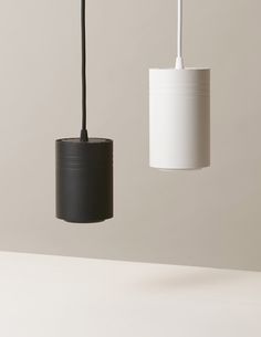 two black and white lamps hanging from the ceiling