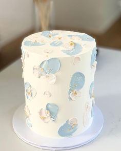 a white and blue decorated cake sitting on top of a table