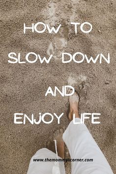 a person standing in the sand with their feet up and text that reads how to slow down and enjoy life