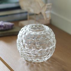 a clear glass vase sitting on top of a wooden table