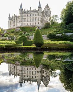 an old castle with its reflection in the water