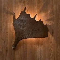 a piece of wood that has been carved into the shape of a leaf on a wooden floor