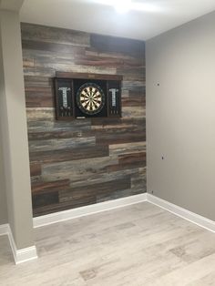 an empty room with a dart in the center and darts on the wall behind it