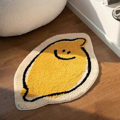 a yellow rug with a smiling face on the floor next to a white toilet in a bathroom