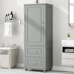 a bathroom with a white sink and gray cabinet