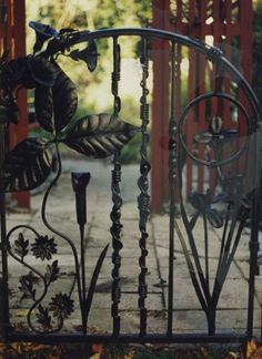 an iron gate with flowers and leaves on it