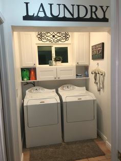 the laundry room has two washers and dryer combos in it, along with cabinets