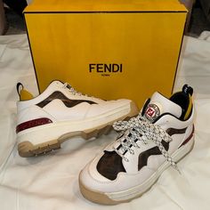 These Super Cool Platform Authentic Fendi Sneakers Have Only Been Rarely Worn. Oringinal Shoe Box And Papers + Receipt Included. They Still Have Not Been Broken In As They Have Only Been Worn Twice. The Crisp White Leather In Combination With The Iconic Double F Fendi Print In Mesh Is So So Stylish. The Yellow Net Details, Speckled Laces, And The Roma And Star Embossed On A Deep Red Make For The Most Decadent Details. And The Shoe Lip Logo Is Amazing. These Were Purchased At Neiman’s Marcus. Fit Fendi Sneakers Women Outfit, Designer Custom Brown Sneakers With Contrast Sole, Fendi Shoe Box, Fendi Match Sneakers, Fendi Shoes Heels, Fendi Print, Fendi Sneakers, Lip Logo, Fendi Shoes