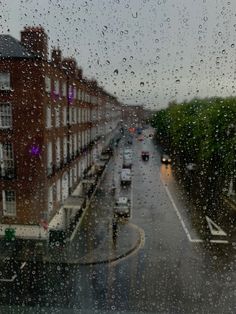 rain drops on the window as cars drive down a street