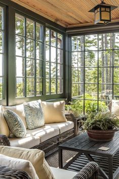 an image of a sun room with lots of windows and couches in front of it