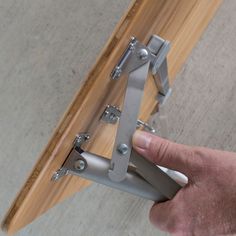 a person is holding onto the handle of a skateboard with metal brackets on it