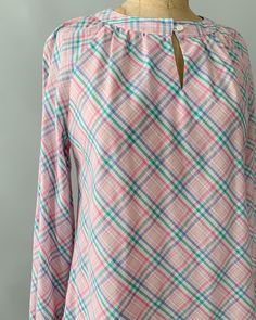 "An adorable spring blouse by Levi's from the late 1970s - early 1980s. Made from a pastel plaid cotton blend in shades of pale pink, blue and green, the blouse has a gathered neckline with a front button closure and keyhole, and long, puffy bishop sleeves that can also be rolled/cuffed and buttoned in place with the attached tab. Looks so cute tucked into high waisted jeans! Measurements Tag: Levi Strauss Material: 55% Cotton 45% Polyester Size: tagged a vintage size 10 and fits a modern small Plaid Long Sleeve Top For Spring, Pastel Long Sleeve Tops For Spring, Preppy Long Sleeve Tops For Spring, Plaid Cotton Blouse For Spring, Cotton Plaid Blouse For Spring, Spring Long Sleeve Preppy Tops, Preppy Long Sleeve Spring Tops, Preppy Spring Blouse, Vintage Plaid Top For Spring