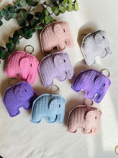 small crocheted elephant key fobs on a table next to a potted plant