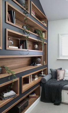 a living room filled with lots of wooden bookshelves next to a gray couch