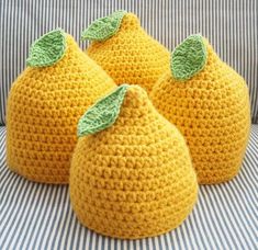 three crocheted lemons sitting on top of a couch