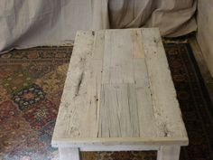 an old wooden table sitting on top of a rug