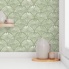 two white vases sitting on top of a counter in front of a green wall