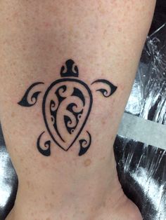 a woman's foot with a turtle tattoo on the side of her ankle,