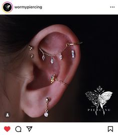 an ear with three different piercings attached to the side of it, and two smaller ones