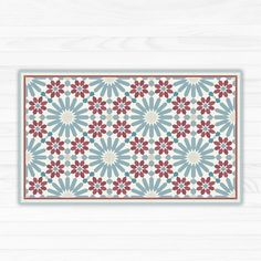 a blue and red place mat on a white wooden surface with an ornate design in the middle