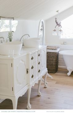 a white bathroom with two sinks and a tub