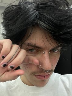 a man with black hair and piercings on his nose