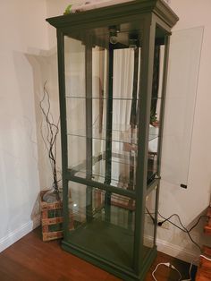 a green glass display case sitting on top of a hard wood floor