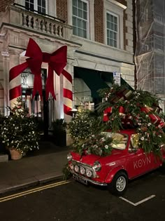 an old red car with a christmas tree on top