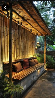 a wooden bench sitting under a bamboo roof