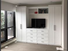 a living room with white cabinets and a flat screen tv