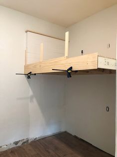 an unfinished loft bed in a white room