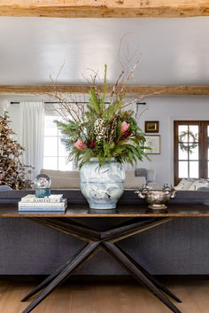 a living room with a couch, coffee table and christmas tree in the back ground