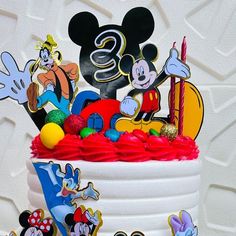 a mickey mouse birthday cake with decorations on it