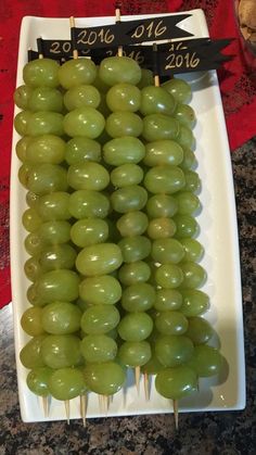 grapes are arranged on toothpicks in a dish