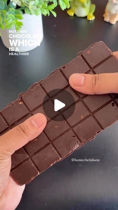 someone is holding a chocolate bar with their thumb on the top and one hand in front of it