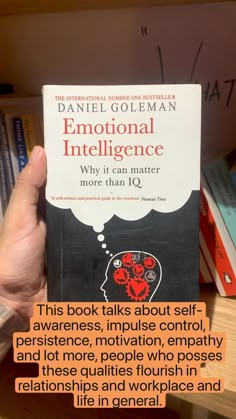 a person holding up a book in front of bookshelves with the title'this book talks about self - awareness, impuse control, motivation,