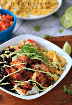 a white bowl filled with chicken, black beans, corn and guacamole