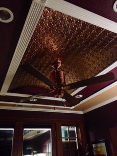 a ceiling fan is hanging from the ceiling in a room with purple walls and wooden doors