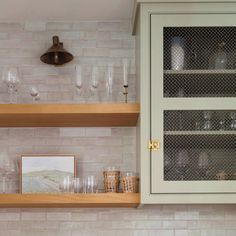 the shelves in this kitchen are filled with wine glasses and other things to put on them