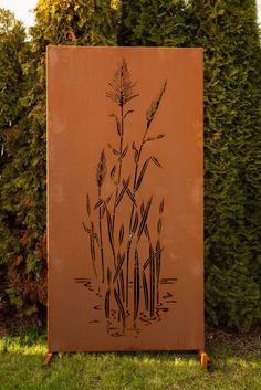 a tall brown sign sitting on top of a lush green field