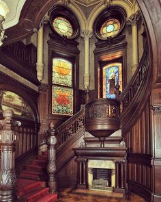 an ornate staircase with stained glass windows in the center and wooden steps leading up to it