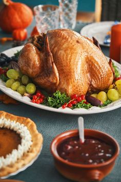 a turkey on a platter with grapes and crackers