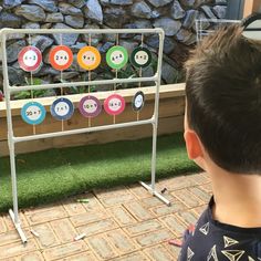 a young boy standing in front of a display with buttons on it's sides