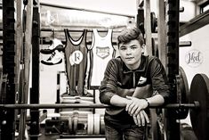 a young man leaning on a bar in a gym