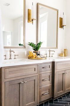 a bathroom with two sinks, mirrors and a stool in front of the counter top