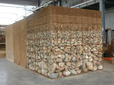 a large pile of rocks sitting inside of a warehouse next to a wall filled with wood